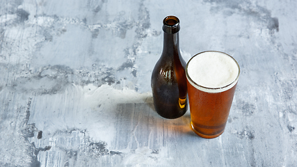 Image showing Glass of light beer on white stone background