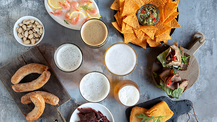 Image showing Top view of beer glasses with foam on top and delicious snacks