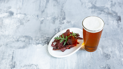 Image showing Glass of beer on the stone table and brick\'s background