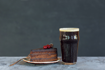 Image showing Glass of dark beer on the stone table and grey background