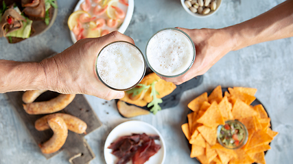 Image showing Top view of beer glasses with foam on top and delicious snacks