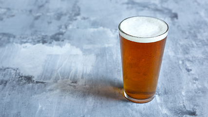 Image showing Glass of light beer on white stone background