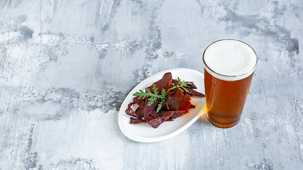 Image showing Glass of beer on the stone table and brick\'s background