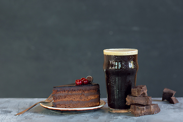 Image showing Glass of dark beer on the stone table and grey background