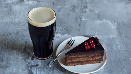 Image showing Glass of dark beer on the stone table background