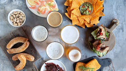 Image showing Top view of beer glasses with foam on top and delicious snacks