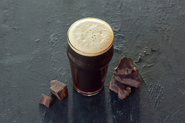 Image showing Glass of dark beer on the stone table background