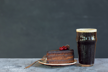 Image showing Glass of dark beer on the stone table and grey background