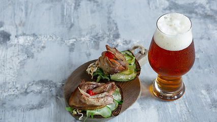 Image showing Glass of beer on the stone table and brick\'s background