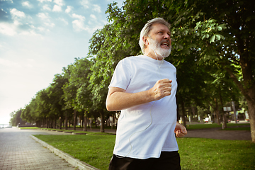 Image showing Senior man as runner with armband or fitness tracker at the city\'s street