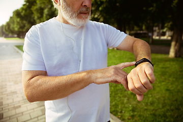 Image showing Senior man as runner with armband or fitness tracker at the city\'s street