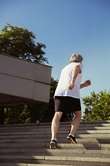 Image showing Senior man as runner with armband or fitness tracker at the city\'s street