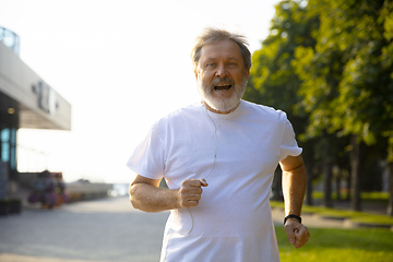 Image showing Senior man as runner with armband or fitness tracker at the city\'s street