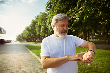 Image showing Senior man as runner with armband or fitness tracker at the city\'s street