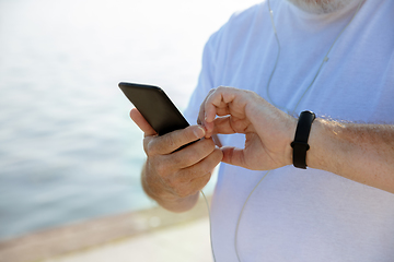 Image showing Senior man as runner with armband or fitness tracker at the riverside