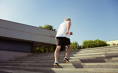 Image showing Senior man as runner with armband or fitness tracker at the city\'s street