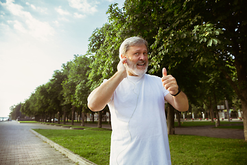 Image showing Senior man as runner with armband or fitness tracker at the city\'s street