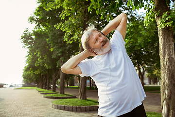 Image showing Senior man as runner with armband or fitness tracker at the city\'s street