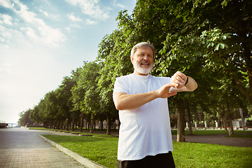 Image showing Senior man as runner with armband or fitness tracker at the city\'s street