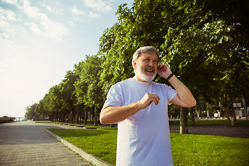 Image showing Senior man as runner with armband or fitness tracker at the city\'s street