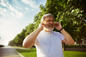 Image showing Senior man as runner with armband or fitness tracker at the city\'s street