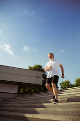 Image showing Senior man as runner with armband or fitness tracker at the city\'s street