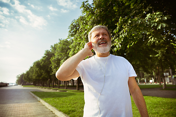 Image showing Senior man as runner with armband or fitness tracker at the city\'s street