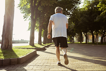 Image showing Senior man as runner with armband or fitness tracker at the city\'s street