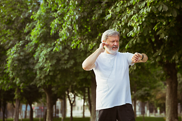 Image showing Senior man as runner with armband or fitness tracker at the city\'s street