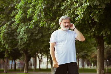 Image showing Senior man as runner with armband or fitness tracker at the city\'s street