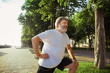 Image showing Senior man as runner with armband or fitness tracker at the city\'s street