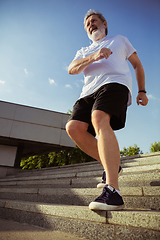 Image showing Senior man as runner with armband or fitness tracker at the city\'s street