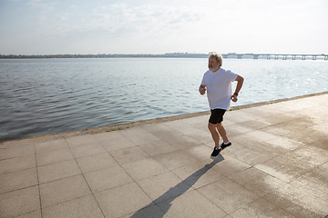 Image showing Senior man as runner with armband or fitness tracker at the riverside