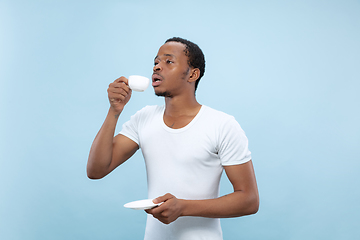 Image showing Half-length close up portrait of young man on blue background.