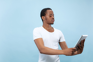 Image showing Half-length close up portrait of young man on blue background.