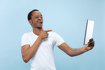 Image showing Half-length close up portrait of young man on blue background.