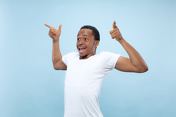 Image showing Half-length close up portrait of young man on blue background.