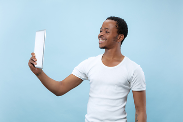 Image showing Half-length close up portrait of young man on blue background.