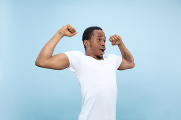 Image showing Half-length close up portrait of young man on blue background.