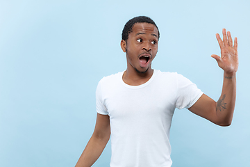 Image showing Half-length close up portrait of young man on blue background.