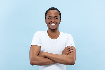 Image showing Half-length close up portrait of young man on blue background.