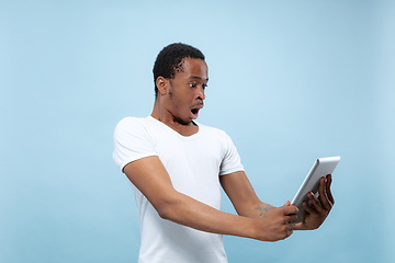 Image showing Half-length close up portrait of young man on blue background.