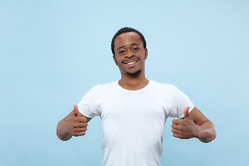 Image showing Half-length close up portrait of young man on blue background.