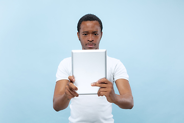 Image showing Half-length close up portrait of young man on blue background.