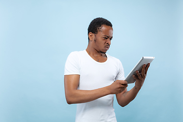 Image showing Half-length close up portrait of young man on blue background.