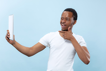 Image showing Half-length close up portrait of young man on blue background.