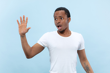 Image showing Half-length close up portrait of young man on blue background.