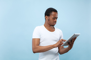 Image showing Half-length close up portrait of young man on blue background.