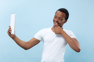 Image showing Half-length close up portrait of young man on blue background.