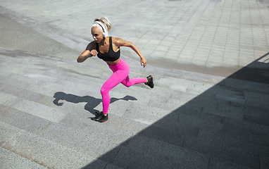 Image showing A young athletic woman working out at the city\'s street